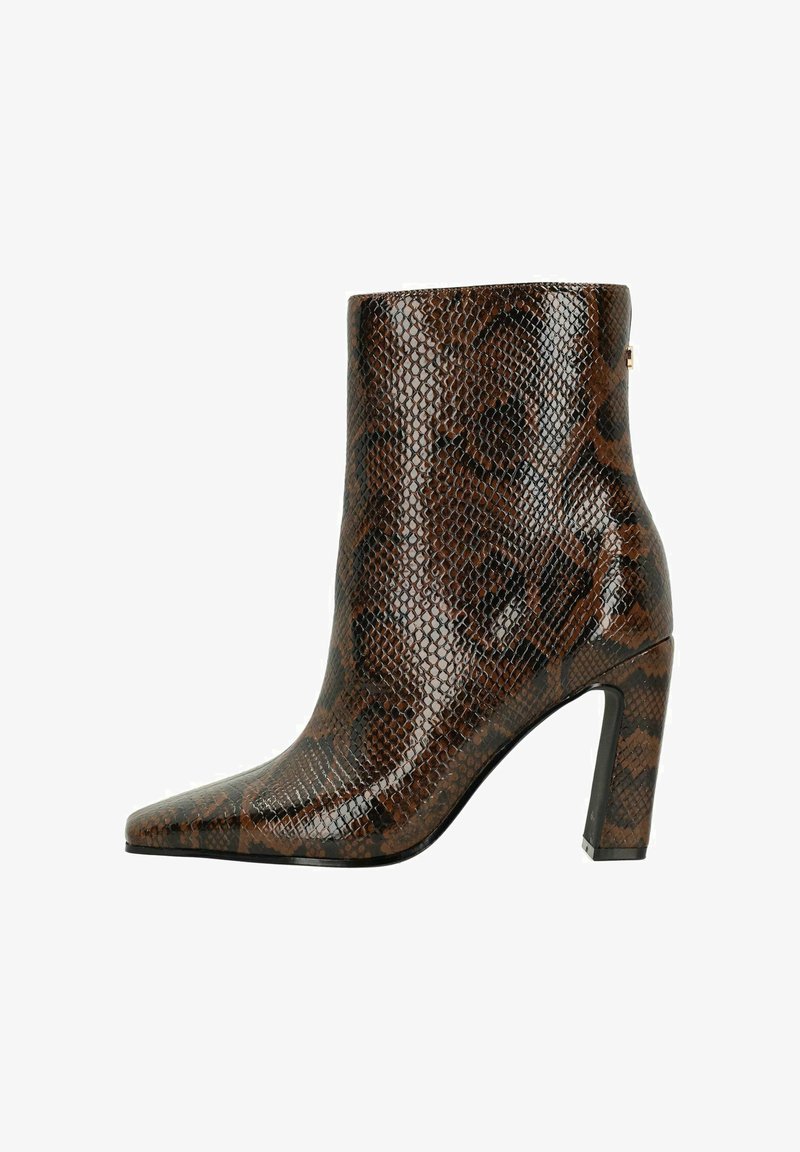 Bottine cheville en imprimé serpent brun avec un bout pointu, un talon haut et une texture brillante. Présente une finition lisse et un subtil détail en métal.