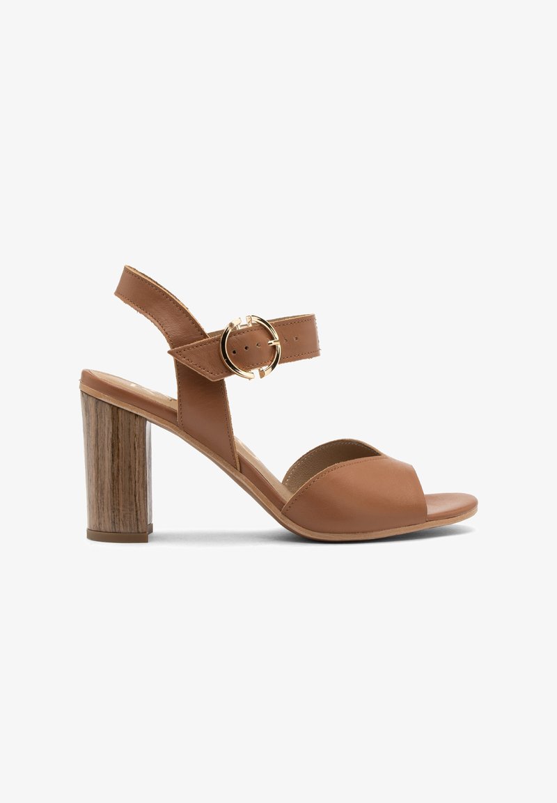 Brūni ādas augstpapēžu sandales ar atvērtu purngalu un potītes siksniņu, kurām ir zelta apļa sprādze un teksturēta koka blokpapēdis.