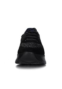 Sneaker nera con tomaia testurizzata, lacci neri e suola spessa, mostrata da un'angolazione frontale su sfondo bianco.