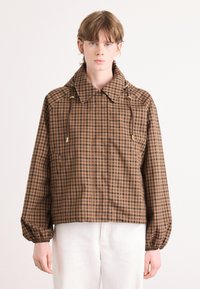Karierte braun-schwarze Jacke mit Kragen, Fronttaschen, elastischen Bündchen und Kordelzugdetails.