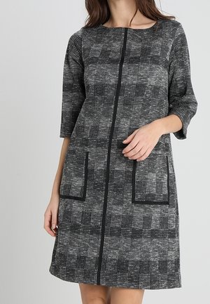 Robe à carreaux noir et gris avec des manches trois-quarts, un décolleté arrondi, deux poches avant et un tissu texturé.