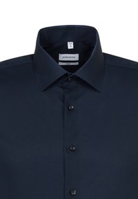 Camicia blu navy a maniche lunghe. Presenta un colletto classico, chiusura a bottoni e un tessuto in cotone misto liscio senza motivi o accentuazioni visibili.