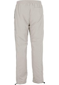 Lichtgrijze, geïsoleerde broek met een tailleband met trekkoord, zijzakken en witte piping langs de buitennaden. Zachte textuur en comfortabele pasvorm.