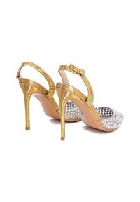 Sandali con tacco alto in oro con finitura lucida, caratterizzati da una punta decorata con strass trasparenti, design slingback e sottile tacco a stiletto.