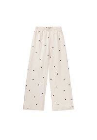 Pantalones de pierna ancha color beige claro, elaborados con una tela suave, que presentan un patrón de corazones negros en toda su extensión y una cinturilla elástica para mayor comodidad.