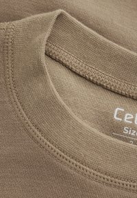 Braunes Baumwoll-T-Shirt mit geripptem Rundhalsausschnitt. Hat eine glatte Textur und gestickte Details. Größenetikett sichtbar innen.