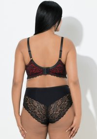 Zwarte kanten bh met rood bloemmotief en verstelbare bandjes, gecombineerd met hooggetailleerde zwarte bikinibroekjes met kanten rand.