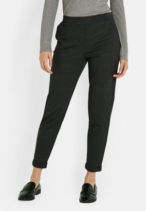 Pantalons à motifs noir et blanc avec une coupe fuselée, en tissu texturé. Ils disposent d'une taille lisse et de poignets retournés.
