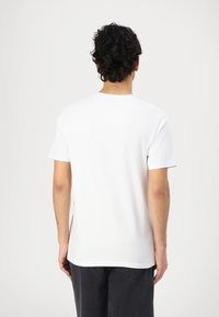 White cotton T-shirt with a crew neck and short sleeves, featuring a smooth texture and a straight cut design, shown from the back.