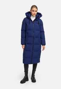 Navy blue padded coat with a hood, long length, front zipper, and adjustable drawstring. Features two side pockets and a smooth texture.