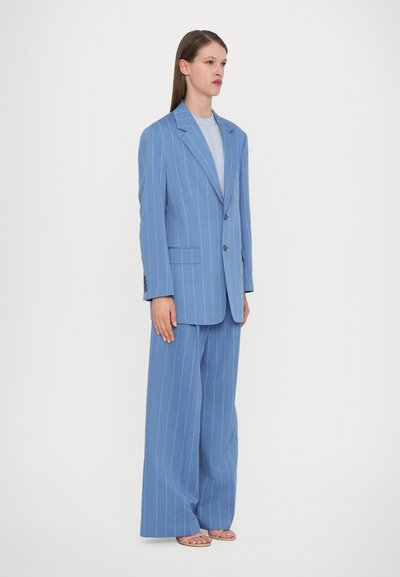 Light blue pinstripe suit with a tailored blazer and wide-leg trousers. Material appears smooth, featuring notch lapels and front pockets.