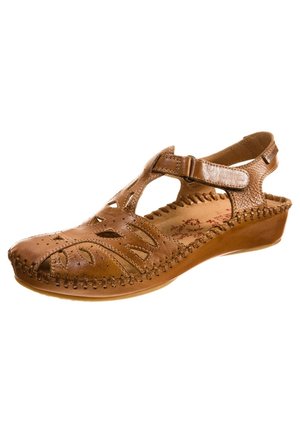 Brun lædersandal til kvinder med udskårne blomsterdesigns, justerbar velcrostrop og syningsdetaljer på en lav kilehæl.