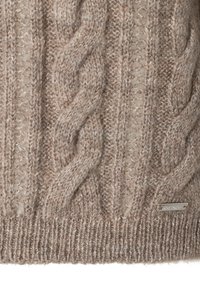Gestrickter Pullover aus einem hellbraunen Wollmix, mit strukturiertem Design, geripptem Saum und einem kleinen metallischen Markenschild unten rechts.
