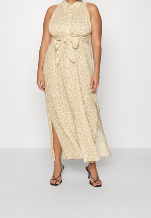 Ærmeløs beige maxikjole med hvid girafprint, knapper foran, bindebånd i taljen, sidelomme, båret med sorte snørestilethælede sandaler.
