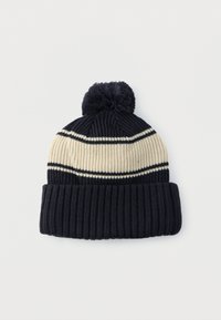 Pleteni klobuk z ribastim vzorcem, z vodoravnimi temno modrimi in kremnimi črtami ter cofkom na vrhu.