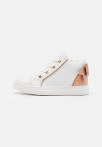 Hvite sneakers med en glatt læraktig overflate, prydet med metallisk rosegull-detaljer, en gjennomsiktig hæl og hvite gummisåler.