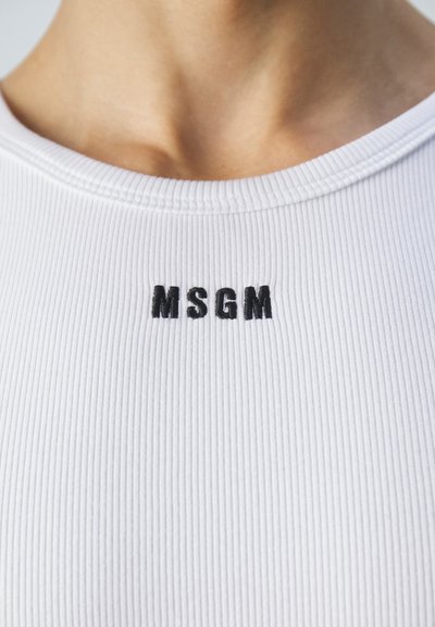 Haut blanc côtelé avec un col rond et un petit logo "MSGM" brodé en noir à l'avant.