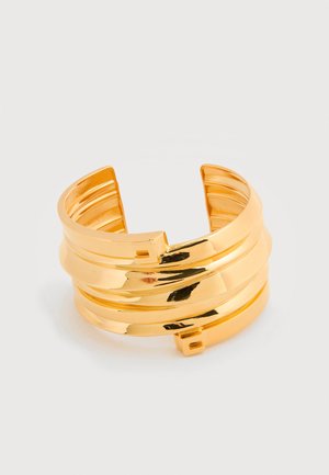 Gullfarget armbånd med lagdelt design, som har glatte og teksturerte seksjoner, åpne ender og en polert finish.