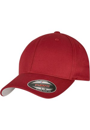 Casquette Flexfit rouge avec une couronne arrondie et une visière courbée. Texture de tissu lisse. Présente un autocollant de logo à l'avant avec le texte de la marque.