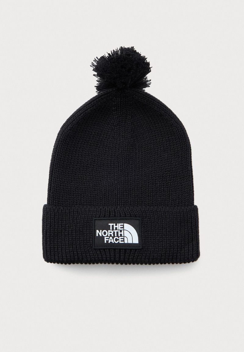 Svart strikket vinterlue med pom-pom og brettet kant som har et rektangulært merkelapplogo med teksten "The North Face."