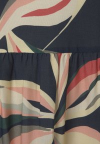 Tissu à motif floral dans des tons bleu marine, crème et pastel ; présente une couture froncée pour la texture et un design fluide.