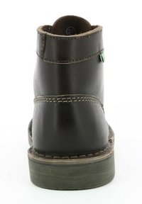 Bruine leren enkelboot met een ronde neus en een licht verhoogde hak. Beschikt over beige stiksels en een kleine groene accent aan de zijkant.