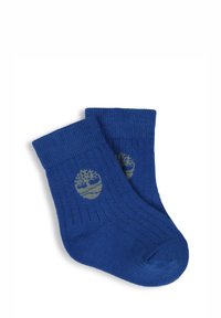 Chaussettes en coton bleu avec une texture côtelée et un revers replié. Présentent un logo d'arbre vert sur chaque chaussette. Design simple, adapté pour une tenue décontractée.