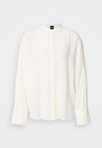 Hosszú ujjú, krémszínű blúz sima anyagból; mandzsettagallér, elülső gombsor, gombos mandzsetták és laza szabás.