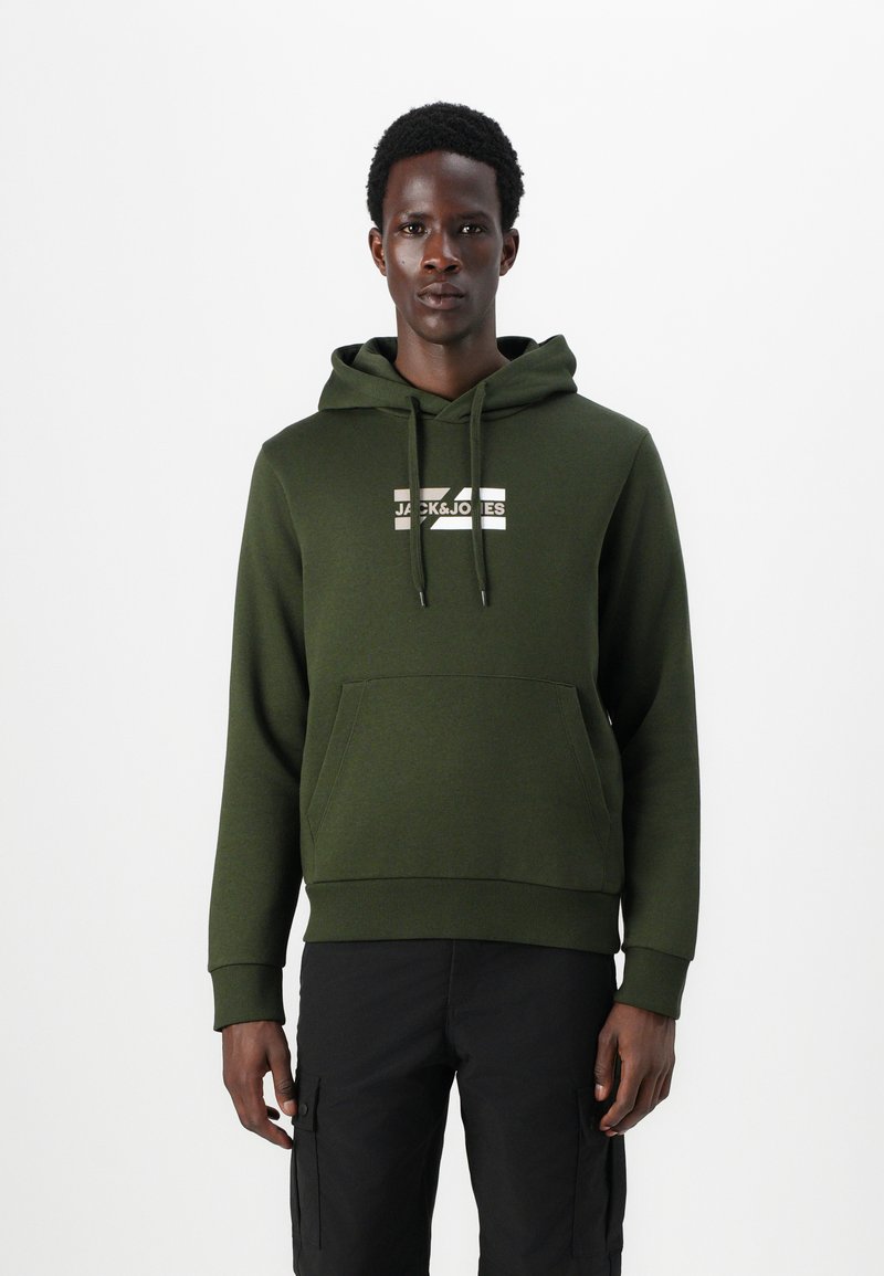 Green hoodie with a front kangaroo pocket, drawstring hood, and white logo print. Soft texture and fitted design. Paired with dark pants.
