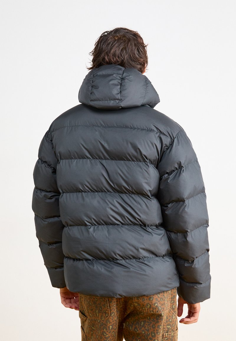 Schwarze Pufferjacke mit hohem Kragen, mit einem gesteppte Design und abgerundetem Rücken. Glatte Textur, leichtes Erscheinungsbild, ohne sichtbare Hardware.