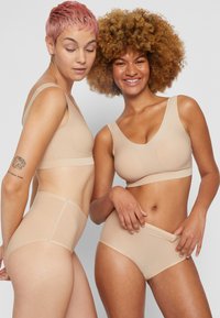 Nude lightweight fabric underwear set featuring a wireless bra with a v-neckline and high-waisted briefs with a smooth finish.