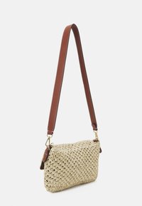Torebka z plecionego beżowego słomy o prostokątnym kształcie, z brązowym skórzanym paskiem, złotymi akcentami i teksturowaną powierzchnią.
