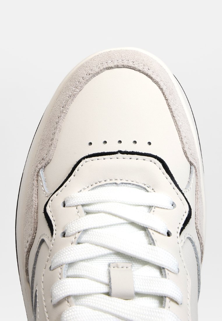 Weiße Ledersneaker mit glatter Oberfläche, grauen Wildlederakzenten, perforiertem Zehenbereich und weißen Schnürsenkeln. Schwarzes Logo-Detail an der Seite.
