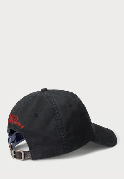 Black cotton cap with adjustable brown leather strap. Features embroidered "POLO" in red. Classic curved brim design.