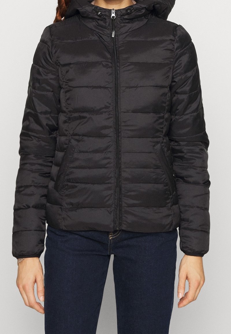 Svart puffjacka med dragkedja fram, quiltat mönster och huva. Tillverkad av ett slätt, glansigt material med en figurnära design.