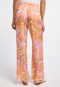 Bunte, gemusterte weitgeschnittene Hosen in einem Design mit pinken, gelben und weißen Wirbeln. Mit elastischem Bund. Weicher, leichter Stoff.