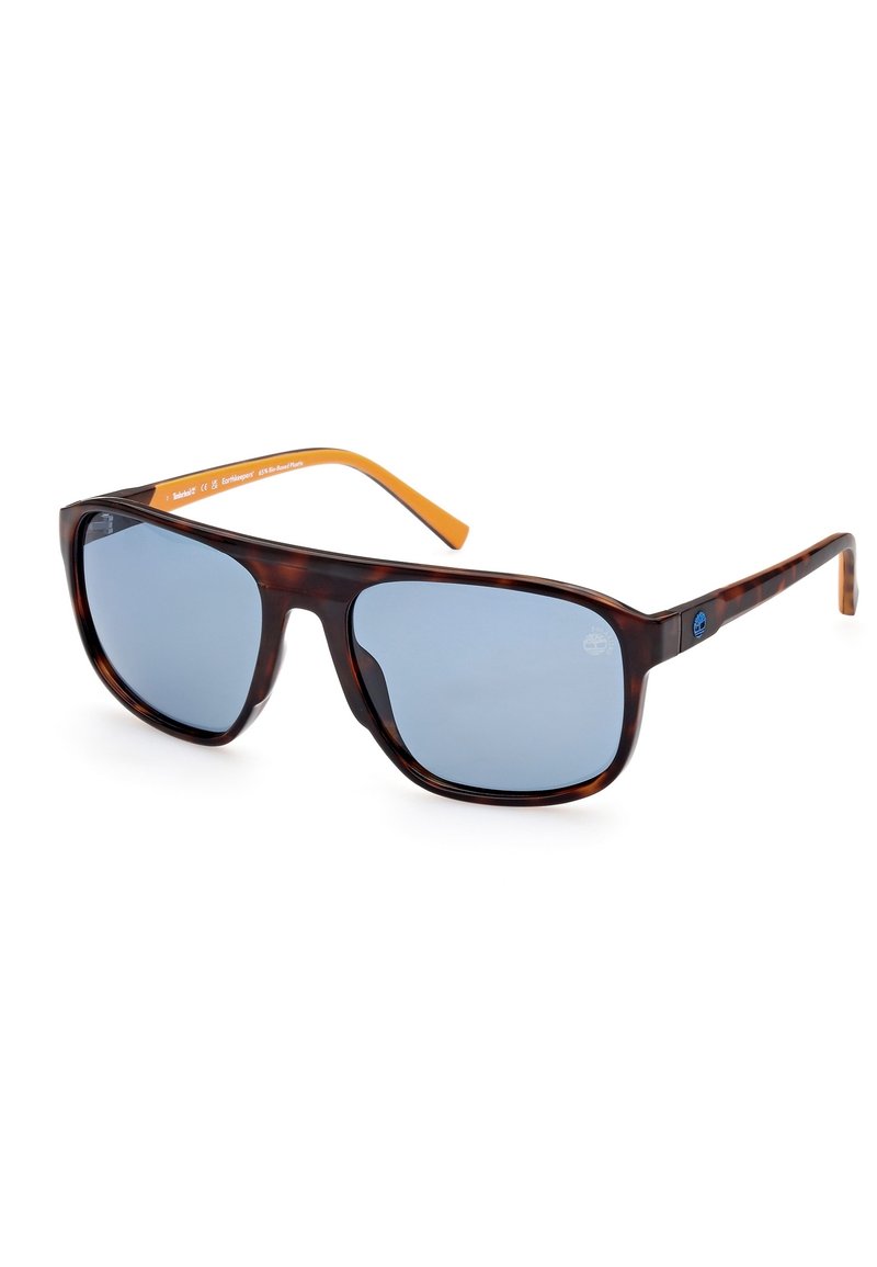 Occhiali da sole tartaruga marrone con lenti grigie, forma angolare, dettagli arancioni sulle tempie e logo sul lato. Montatura in plastica leggera.