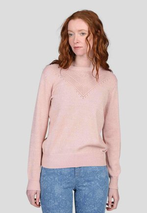 Pull en tricot rose clair avec un motif texturé en V sur la poitrine, à manches longues et à la coupe confortable. Associé à un jean floral bleu.