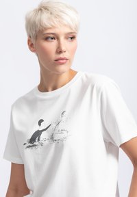 Witte katoenen t-shirt met een zwarte illustratie van een persoon die reikt naar een abstract figuur, ronde halslijn, korte mouwen.