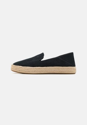 Juodas suedinis espadrilas su pintu džutiniu padu, pasižymintis lengvu įdėjimo dizainu ir V formos išpjova viršuje, palengvinančia įsidėjimą.
