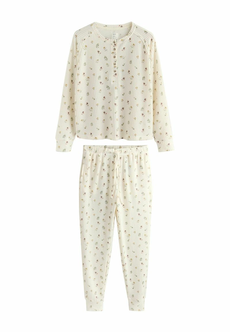 Let sæt pyjamas af let bomuld med en cremefarvet baggrund og pastelfarvede blomsterprint. Ribbet tekstur, lange ærmer og elastik i taljen.