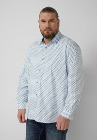 Hellblaues Hemd mit Knopfleiste und geometrischem Muster in dunklerem Blau, lange Ärmel und eine Brusttasche, hergestellt aus glattem Stoff.