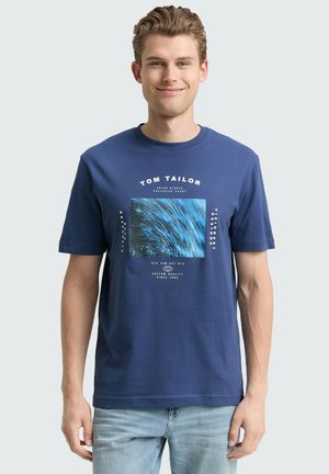Navy blue cotton t-shirt with a crew neck, featuring a rectangular graphic design in blue tones and white text elements.