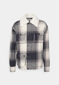 Kraciasta kurtka z białym kołnierzem z sztucznego futra, w kolorach granatowym i szarym, z zatrzaskami i dwoma kieszeniami na piersi zapewniającymi bezpieczne przechowywanie.