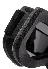 Fekete párnázott pánt tépőzárral, matt textúrával és sima éllel. Egy kidomborodó felületen található "MADE IN ITALY" címke.