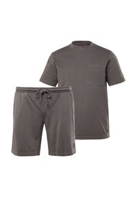 Szary bawełniany t-shirt z krótkim rękawem i kieszonką na piersi, w zestawie z dopasowanymi szortami na sznurku. Oba elementy mają miękkie, teksturowane wykończenie.