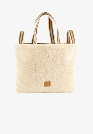 Bolso tote de color crema con una textura suave y aterciopelada. Cuenta con una parche de logo de cuero marrón y dos asas de tela a rayas en verde y rosa.