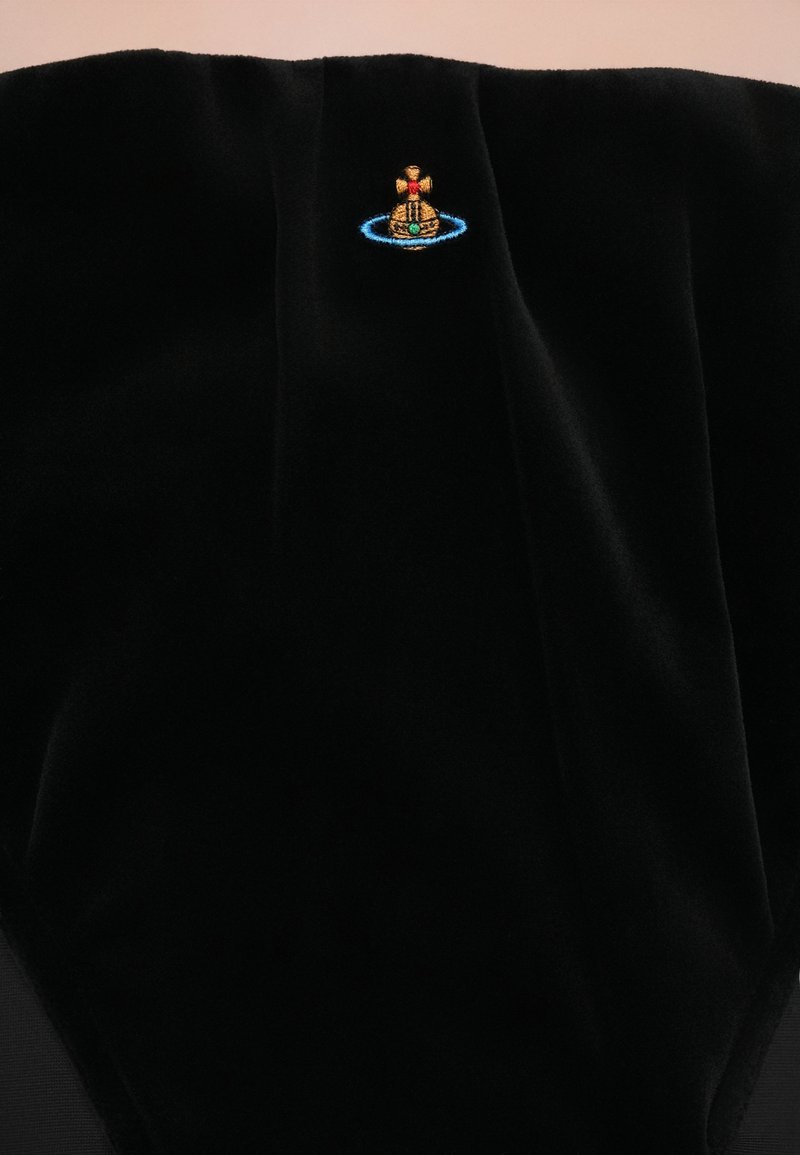 Svart sammetstyg med en liten broderad flerfärgad orb och ring-logotyp nära mitten upptill.