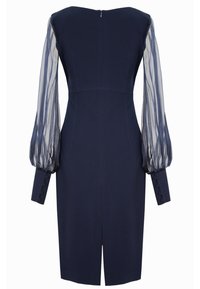 Granatowa sukienka o dopasowanej sylwetce, z przezroczystymi bufkami i zapięciem na guziki przy mankietach. Posiada zamek błyskawiczny z tyłu oraz rozcięcie na dolnym końcu dla swobody ruchów.