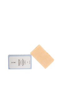 Barra idratante solida al miele accanto al suo packaging rettangolare azzurro chiaro e bianco etichettato in italiano e inglese.